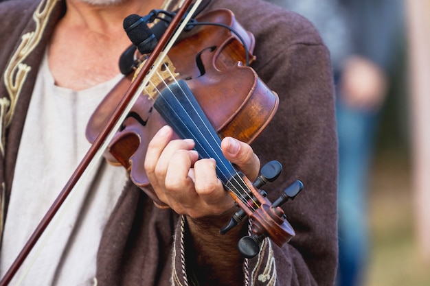 Violine in den Händen eines Musikers während eines Konzerts_