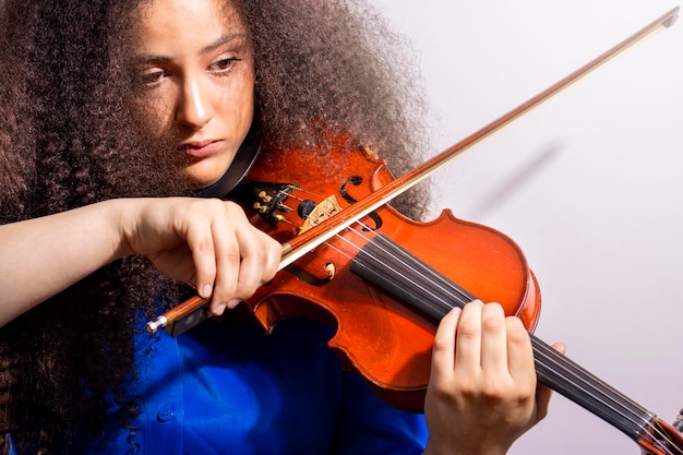 Violinista afro tocando violino em fundo branco Closeup