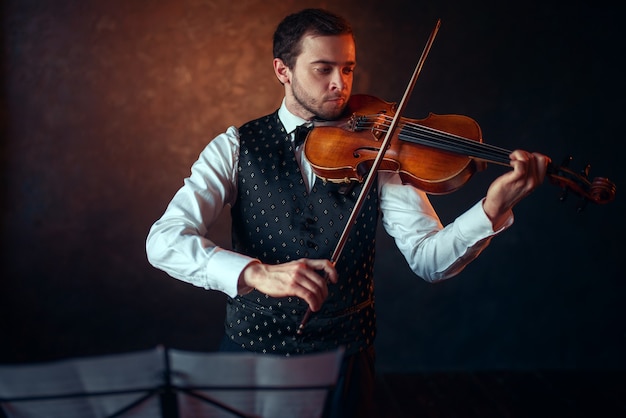 Violinista masculino tocando música clásica en violín