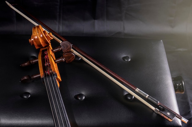 Violoncelo e arco no banco do piano