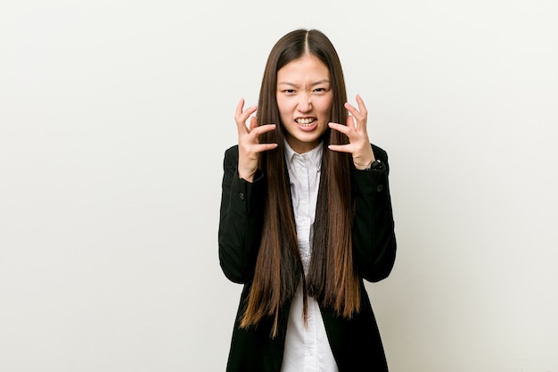 Virada consideravelmente chinesa nova da mulher de negócio que grita com mãos tensas.