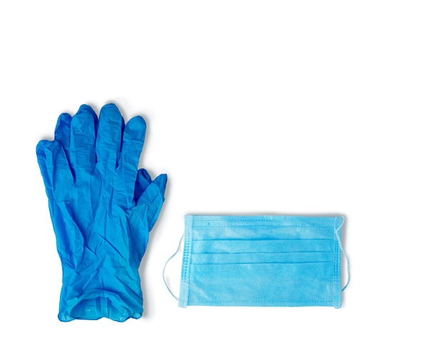 Virenschutz blaue Gummihandschuhe und eine medizinische Maske auf einer weißen Oberfläche.
