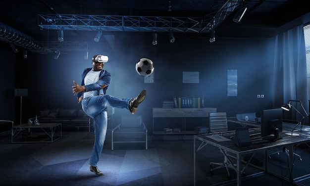 Virtual-Reality-Headset auf einem schwarzen Mann, der Fußball spielt