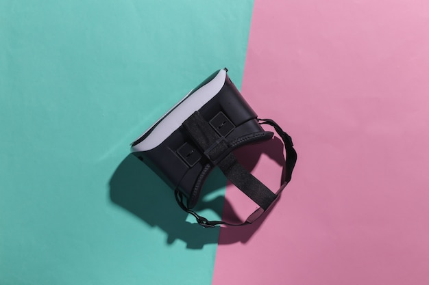 Virtual-Reality-Headset auf rosa blauem Pastellhintergrund mit Schatten. Ansicht von oben. Fliege lag. Minimalismus