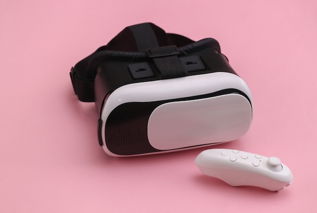 Virtual-Reality-Headset mit Joystick auf rosafarbenem Hintergrund. Moderne Geräte