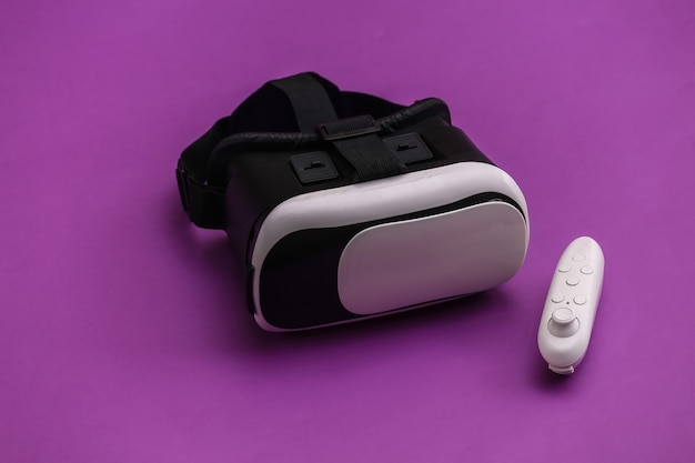 Virtual-Reality-Headset mit Joystick auf violettem Hintergrund. Moderne Geräte