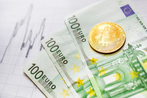 Virtuelles Geld goldene Bitcoin auf Hundert-Euro-Scheinen und Papier-Forex-Chart-Hintergrund Tauschen Sie Bitcoin-Bargeld gegen einen Euro aus