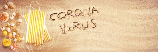 Vírus corona escrito na areia de férias