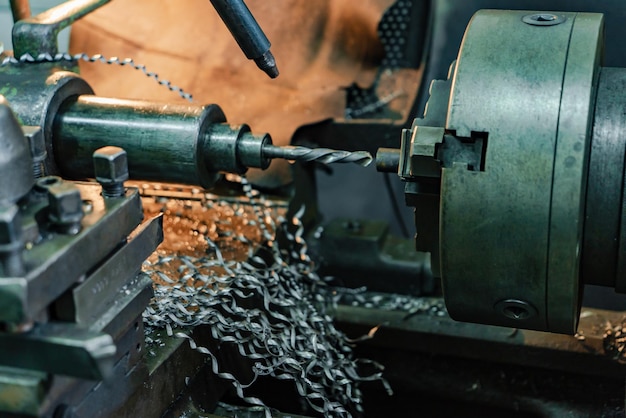 Virutas de metal caen de un torno en el lugar de trabajo en la planta Primer plano