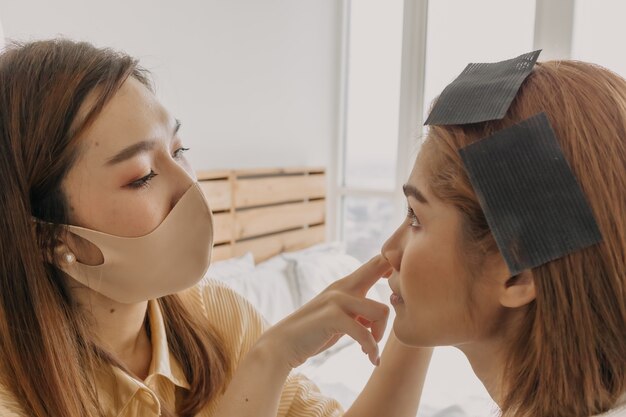 Visagistin trägt Make-up auf die Augen der Kunden auf