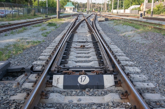 Visão abstrata das setas ferroviárias. Um interruptor de desvio para trilhos no tráfego ferroviário. Trilhos, travessas e brita na via férrea. Mudando de transição.