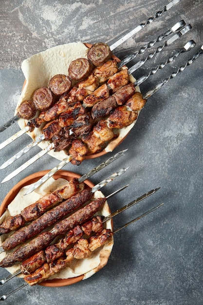 Foto visão aérea da variedade de shashlik e kebabs sobre fundo cinza