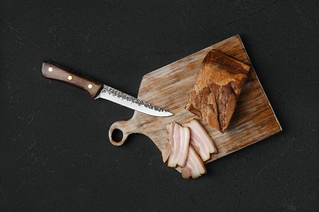 Foto visão aérea de bacon de porco defumado com pão integral e ovos em uma tábua de madeira