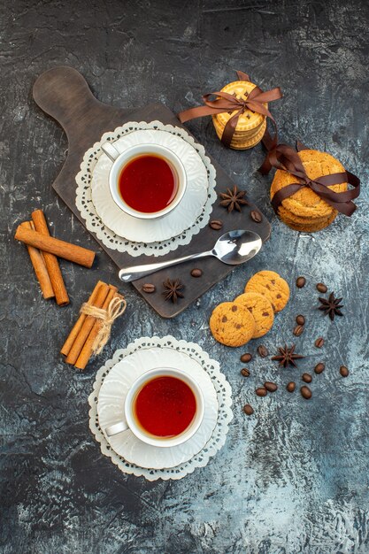 Visão aérea de biscoitos e limas de canela empilhados em uma tábua de madeira no fundo de gelo