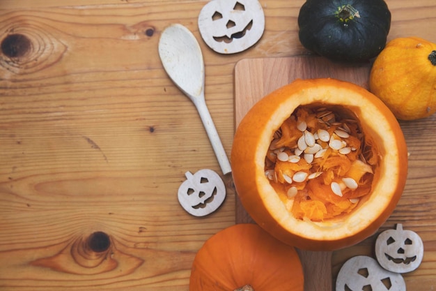 Visão aérea de uma abóbora laranja sendo esculpida em uma lanterna para decoração de halloween