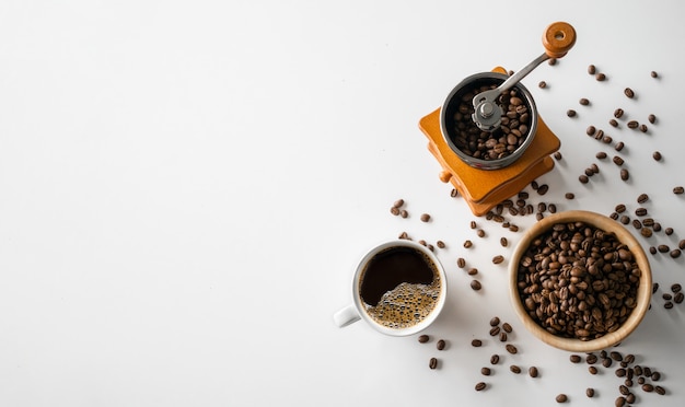 Visão aproximada de grãos de café com xícara de café e moedor