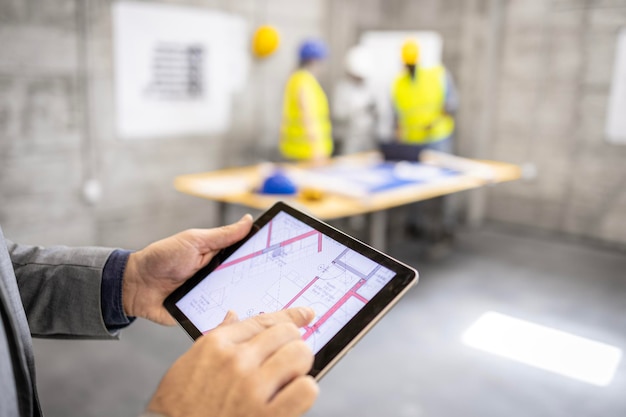 Visão aproximada do tablet digital mostrando a planta de construção no canteiro de obras