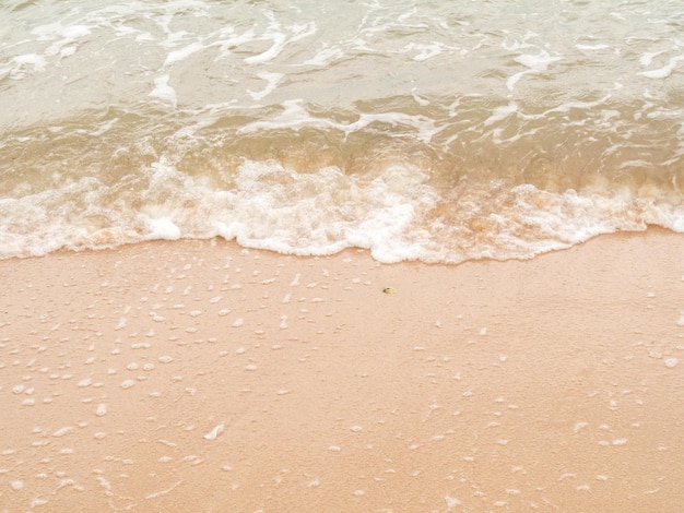 visão de alto ângulo. As ondas do mar atingem a praia ou a costa e as bolhas de ar. Areia molhada, água do mar