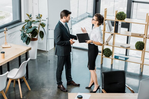 Visão de alto ângulo de colegas de trabalho conversando no escritório