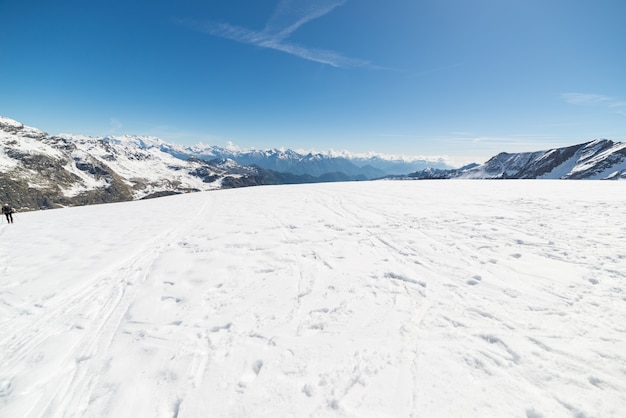 Foto visão de grande angular de uma estância de esqui à distância com picos de montanha elegante surgindo