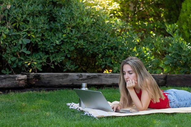 Visão de meio corpo de jovem trabalhando como freelancer em todo o mundo cercado pela natureza