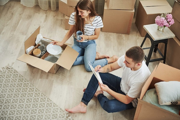 Visão do topo. Casal jovem alegre em seu novo apartamento. Concepção de movimento.