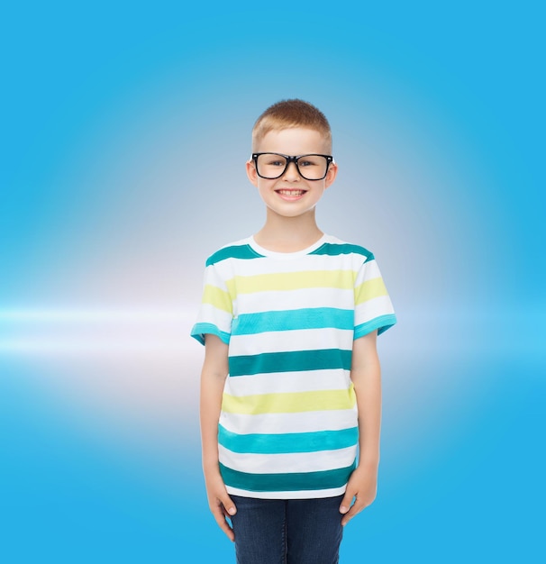 visão, educação e conceito de escola - menino sorridente em óculos sobre fundo azul com luz laser