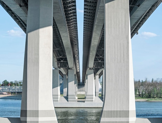 Visão em perspectiva dos pilares de apoio da ponte ou rodovia através do rio fundo industrial