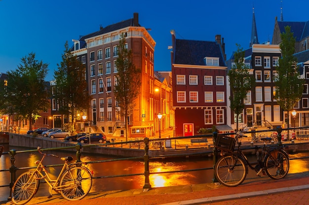 Visão noturna da cidade do canal de Amsterdã, ponte, casas típicas e bicicletas, Holanda, Holanda.