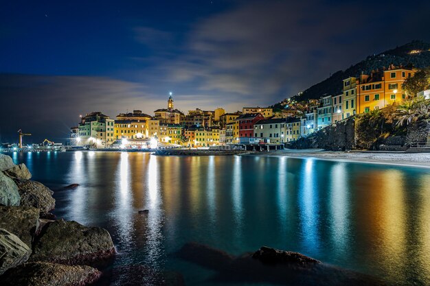 Visão noturna da cidade velha de Bogliasco iluminada com luzes refletindo no mar