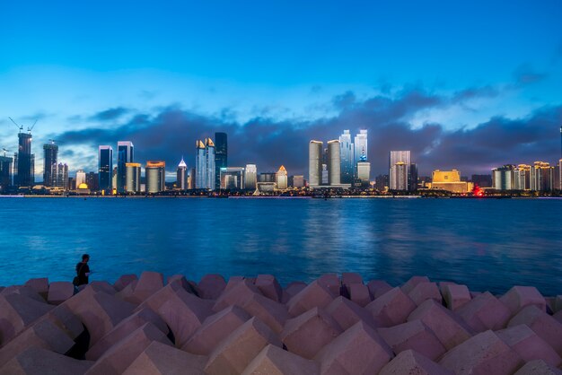 Visão noturna da paisagem de arquitetura urbana moderna em Qingdao