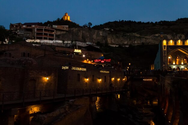 Visão noturna do antigo distrito de Abanotubani, conhecido por seus banhos de enxofre em Tbilisi, Geórgia