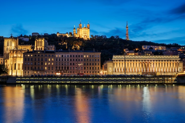 Visão noturna sobre o rio saône para a catedral fourviere na cidade de lyon.