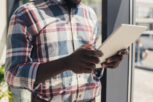 visão recortada de homem afro-americano usando tablet digital