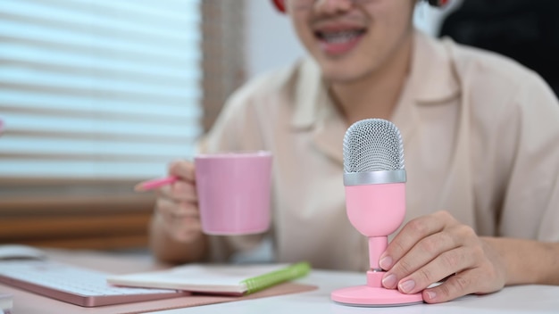 Visão recortada do homem sentado na frente do microfone falando e gravando podcast no estúdio doméstico Tecnologia de mídia de massa e conceito de pessoas