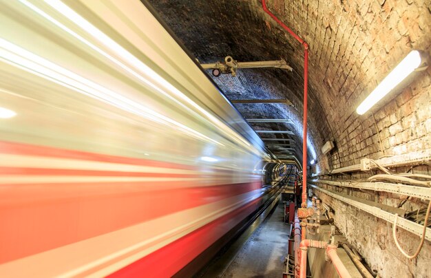 Visão sombria do túnel de metrô com trem em movimento