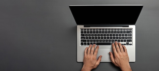 Visão superior das mãos digitando no laptop em fundo preto escuro Local para espaço de cópia de texto