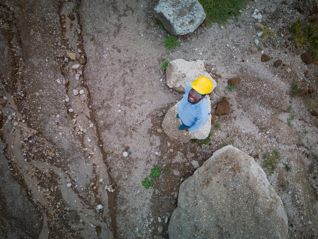 Visão superior do engenheiro afro-americano no canteiro de obras usando óculos e capacete