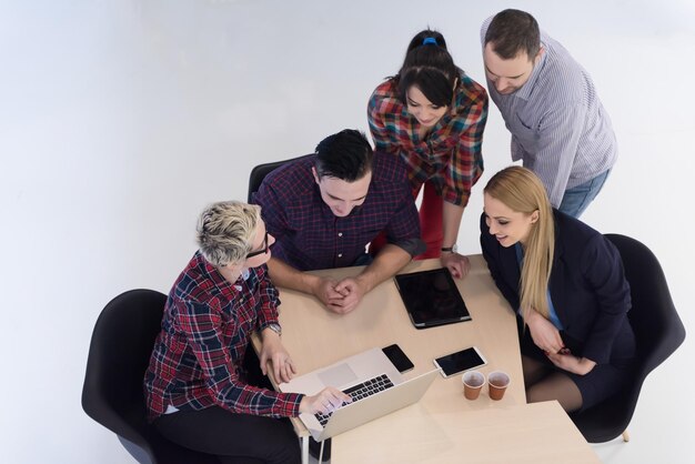 Visão superior do grupo de empresários de inicialização multiétnica na reunião de brainstorming no interior do escritório moderno e brilhante