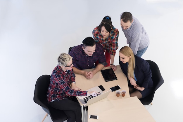 Visão superior do grupo de empresários de inicialização multiétnica na reunião de brainstorming no interior do escritório moderno e brilhante