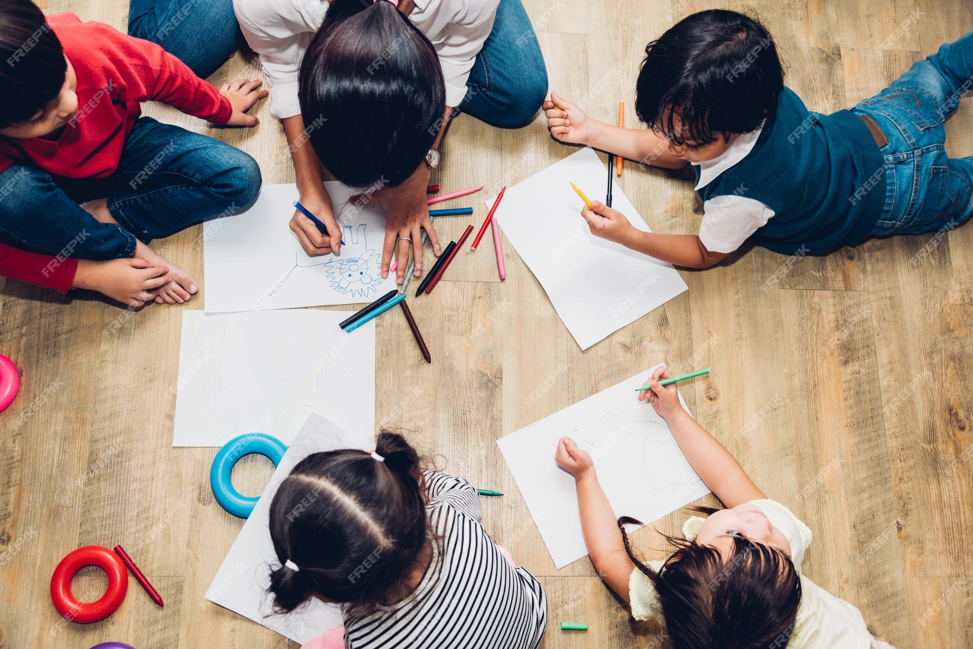 Visão superior grupo de crianças felizes da família garoto menino e menina  pintura de jardim de infância desenhando na educação de professores peper  na sala de jogos interior