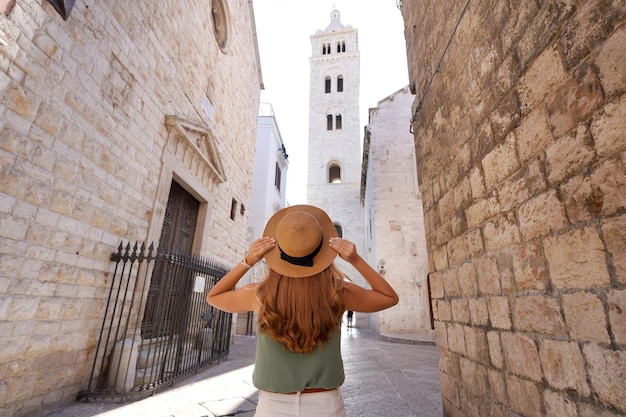 Visão traseira da garota turista explorando a cidade histórica de Barletta Apulia Itália Grande angular