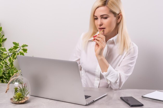 Visão traseira da mulher de negócios conversando com seus colegas sobre o plano em videoconferência. Equipe de negócios usando laptop para uma reunião on-line em videochamada. Grupo de pessoas inteligentes trabalhando em casa