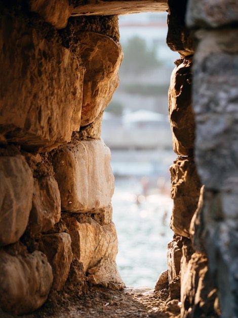 Visão turva através da janela na antiga fortaleza de pedra na cidade de Old Budva Montenegro Conceito de arquitetura Foco suave