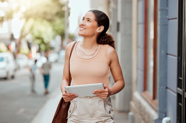 Visión ambiciosa e inspirada mujer creativa caminando en una ciudad urbana sosteniendo una tableta digital Mujer diseñadora explorando visitando y disfrutando de un turismo en una ciudad al aire libre en busca de inspiración