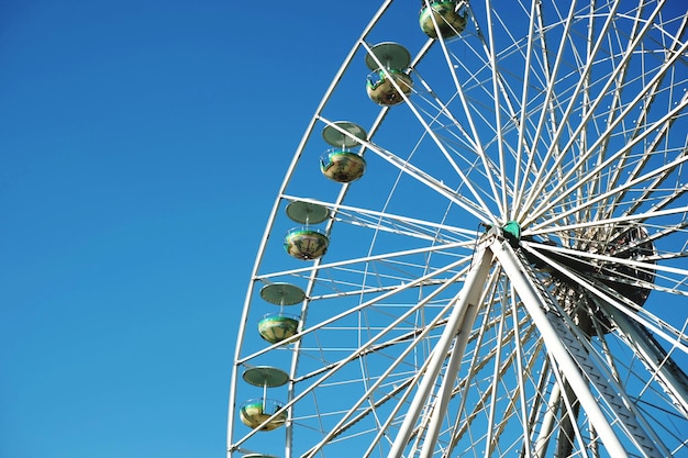 Foto visión de ángulo bajo de la rueda de la ferris contra un cielo azul claro