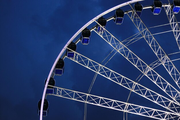 Visión de ángulo bajo de la rueda de la ferris contra el cielo azul