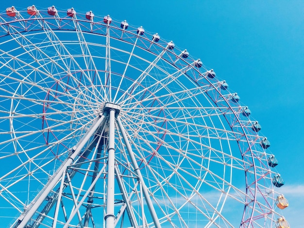 Visión de ángulo bajo de la rueda de la ferris contra el cielo azul