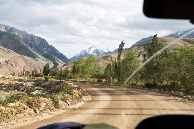 Foto visión desde el coche en el camino al paisaje montañoso nevado kirguistán