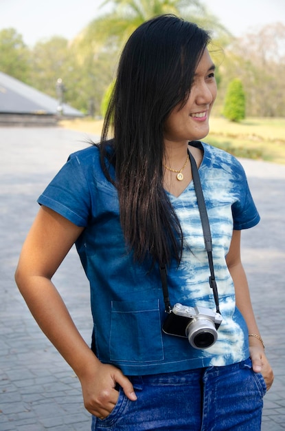 Visita de viagem de mulher tailandesa da ásia e posando para tirar foto no parque de jardim público em sing buri tailândia